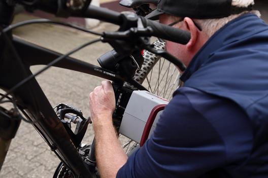 An old man repairs his bicycle